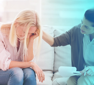 Психолог держит плачущую девушку за плечо
